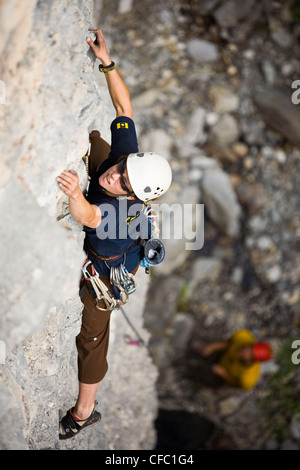 Eine weibliche Rockclimber Heads-up eine Kalkstein-Route im Banff National Park, AB Stockfoto