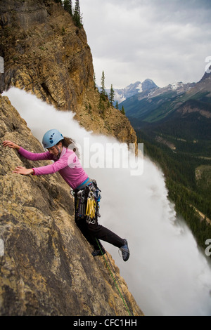 Ein weibliche Kletterer steigt die gespeisten Wasserfälle-Route (5.6) im Yoho National Park, BC Stockfoto