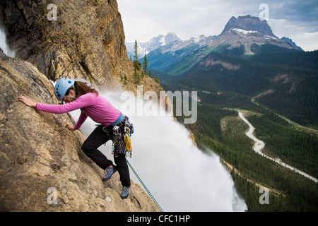 Ein weibliche Kletterer steigt die gespeisten Wasserfälle-Route (5.6) im Yoho National Park, BC Stockfoto