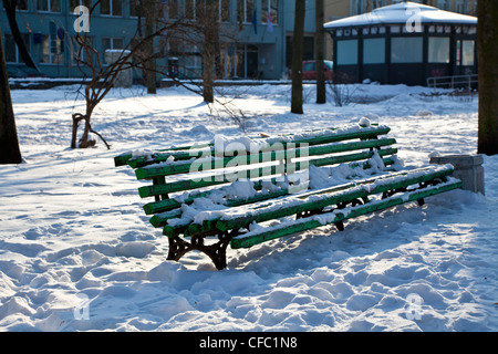 Grüne Bank bedeckt mit Schnee in einem Park in Vilnius, Litauen (schwarz und weiß erhältlich bei CFC1M0) Stockfoto