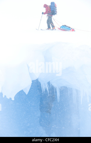 Ein Skifahrer schleppt einen Schlitten über eine offene Gletscherspalte im Bereich von Darwin von Südchile Stockfoto