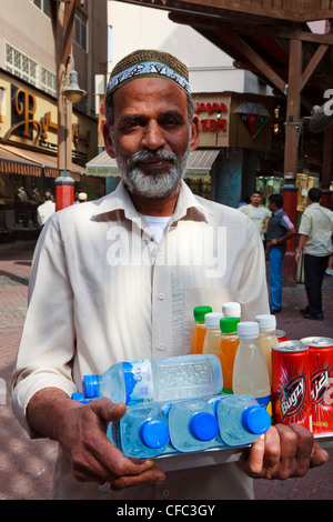 Arabische Mann verkaufen Erfrischungen an alkoholfreien Getränken und Wasser aus einem Fach in der alten Stadt Souk, Dubai Stockfoto