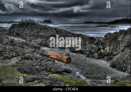 Dunkle stürmische Tofino Seelandschaft mit Felsen und melden Sie sich im Vordergrund, Inseln auf der Rückseite. Stockfoto