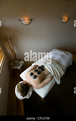 junge Frau entspannt empfangen heißen Stein massage Stockfoto