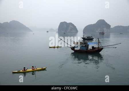 Kajak und Fischerboot, Halong Bay, Quang Ninh, Vietnam Stockfoto