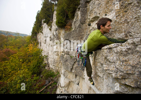 Ein junger Mann klettert den Abgrund 5.10 b, Rattle Snake Punkt, ON, Canada Stockfoto