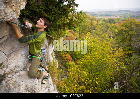 Ein junger Mann klettert den Abgrund 5.10 b, Rattle Snake Punkt, ON, Canada Stockfoto