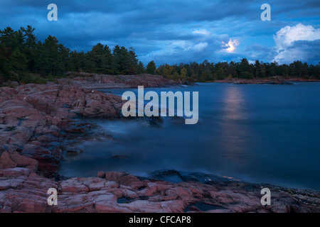 Vollmond wird vorgestellt, wie Wolken über Georgian Bay in Killarney Provincial Park im Norden von Ontario zu übergeben. Stockfoto