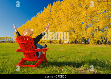 Mann sitzt Stuhl Kante Heu Feld Shelterbelt Herbst Stockfoto