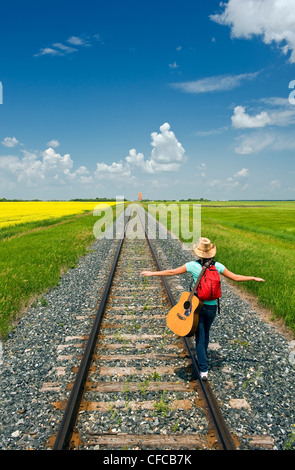 18 jährige Mädchen Gitarre zu Fuß entlang der Eisenbahn Stockfoto