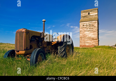 alten Traktor mit verlassenen Aufzug im Hintergrund, Dankin, Saskatchewan, Kanada Stockfoto