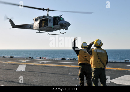 Die Flugbootsfreunde lenken den Start einer UH-1N Huey auf dem Flugdeck des amphibischen Sturmschiffs USS Kearsarge. Kearsarge ist im Gange und absolviert die Grundausbildung der Training Group 1.3 über Wasser. Stockfoto