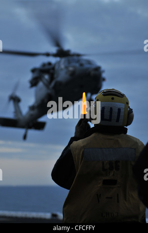 Ein Flugbootsfreund leitet die Landung eines MH-60S Knighthawk während der Flugoperationen an Bord des amphibischen Sturmschiffs USS Kearsarge (LHD 3). Kearsarge ist im Gange und absolviert die Grundausbildung der Training Group 1.3 über Wasser. Stockfoto