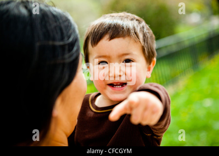 eine Mutter hält und küsst ihre 2 Jahre alten Sohn. Stockfoto