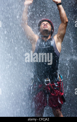 Ein Mann in einem Wasserfall nach Canyoning und Abseilen um die Wasserfälle des Vulkan Arenal in der Nähe von La Fortuna in Costa Rica Stockfoto