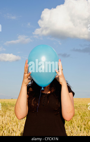 junge Frau mit azurblauen Himmel und Ballon-Hintergrund Stockfoto