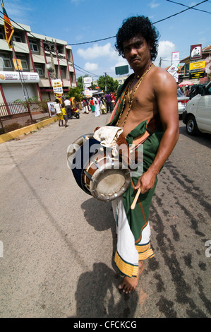 Ein singhalesischer Mann spielt eine traditionelle Trommel während eines Festivals in Negombo, Sri Lanka. Stockfoto