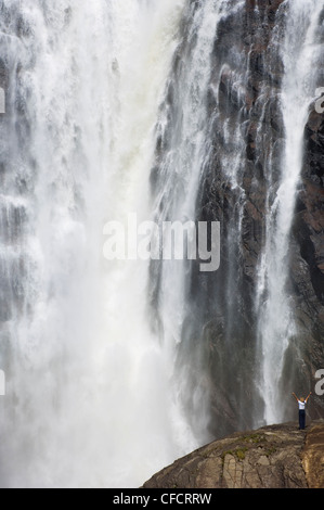 Frau mit ausgestreckten Armen an den Montmorency Falls, befindet sich 10 km östlich von Quebec Stadt, Quebec, Kanada. Stockfoto