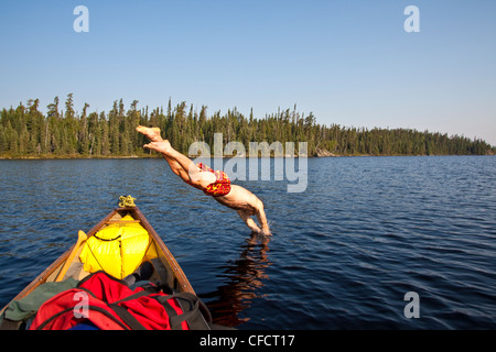 Ein Mann "cooling off" und Tauchen in einem See an einem heißen Tag beim Kanufahren und camping in Wabakimi Provincial Park, Ontario, Kanada Stockfoto