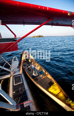 Ein Mann lädt ein Wasserflugzeug nach Hause fliegen nach einer 2-wöchigen Kanutour in Wabakimi Provincial Park, Ontario, Kanada Stockfoto