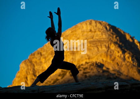 Eine Fit junge Frau praktizieren Yoga während auf einem Felsen klettern Reise, Red Rocks, Las Vegas, Nevada, Vereinigte Staaten von Amerika Stockfoto