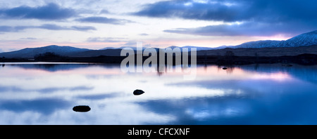 Dawn Blick auf Loch Ba spiegelt den Himmel und Ferne schneebedeckte Berge, Rannoch Moor, Highland, Schottland, Vereinigtes Königreich Stockfoto