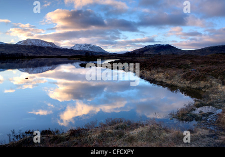 Dawn Blick auf Loch Ba spiegelt den Himmel und Ferne schneebedeckte Berge, Rannoch Moor, Highland, Schottland, Vereinigtes Königreich Stockfoto