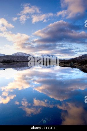 Dawn Blick auf Loch Ba spiegelt den Himmel und Ferne schneebedeckte Berge, Rannoch Moor, Highland, Schottland, Vereinigtes Königreich Stockfoto