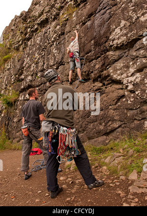 Beobachten Sie zwei Männer, eine sichernde einen Kletterer Patch einer Sport-Route mit einem Seil an Benny Beg, Schottland zu dehnen Stockfoto