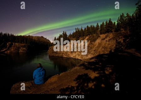 Person gerade Nothern Lichter über Miles Canyon, Whitehorse, Yukon, Kanada. Stockfoto