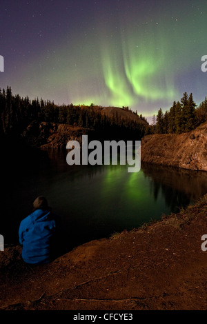 Person gerade Nothern Lichter über Miles Canyon, Whitehorse, Yukon, Kanada. Stockfoto