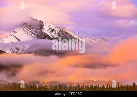 Mount Rundle, Banff Townsite bei Dämmerung und dramatische Wolken. Banff Nationalpark, Alberta, Kanada. Stockfoto