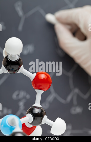 Molekül-Modell mit Forscher schreiben an der Tafel im Hintergrund Stockfoto