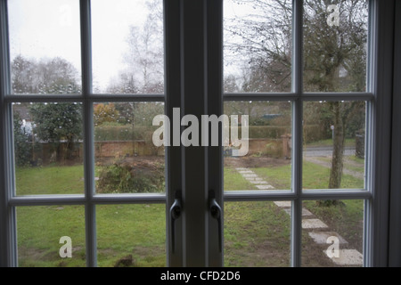 Regentropfen auf Glasscheibe Fenster Blick auf Garten Stockfoto