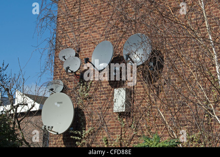 Gruppierung von kleinen und großen Satellitenschüsseln auf der Seite der Wohnblock in Wandsworth, Südwesten von London, england Stockfoto