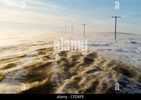 Straße bedeckt mit Schneeverwehungen, in der Nähe von Verwood, Saskatchewan, Kanada Stockfoto