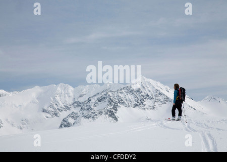 Eine weibliche Backcountry Skifahrer entlang einer Strecke in den verschneiten Bergen Häuten. Stockfoto