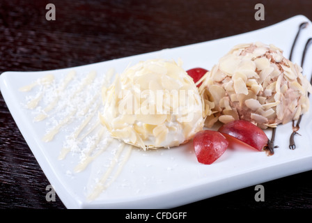 Dessert-Satz von Eis mit Mandeln, Schokolade und Weintrauben Stockfoto