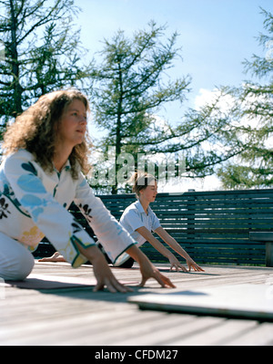 Frauen praktizieren Yoga auf einer Terrasse, Vigilius Mountain Resort, Vigiljoch, Lana, Trentino-Alto Adige/Suedtirol, Italien Stockfoto