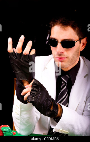 Blick von einem Gangster-Mann einige Karten und Poker, Anpassung der Handschuhe. Stockfoto