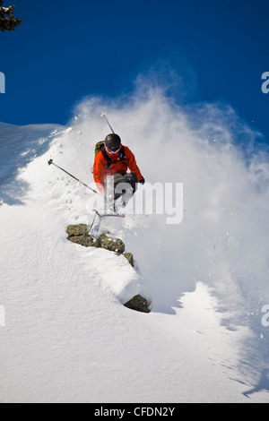 Ein männlicher Skifahrer fängt etwas Luft in frischen Pulverschnee während Skitouren in Sol Mountain Lodge, Monashee, British Columbia, Kanada Stockfoto