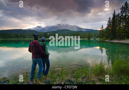 Paar genießen Sie den Blick auf Lake Edith und Mount Pyramide in den Rocky Mountains, in der Nähe von Jasper, Alberta, Kanada Stockfoto