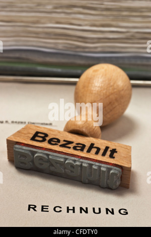 Ein Stempel Mit der Aufschrift Bezahlt Liegt Auf Einer Rechnung | Ein Stempel mit der Inschrift in Deutsch bezahlt ist auf einer Rechnung Stockfoto