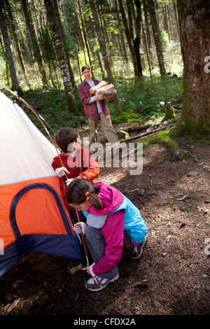 Junges Mädchen hilft, ein Zelt aufstellen. Stockfoto