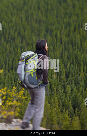 Eine junge Frau nimmt in der Ansicht während auf einer Wanderung in Kananaskis, Alberta, Kanada Stockfoto