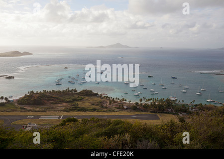 Union Island Airport liegt an einer Bucht mit festgemachten Segelbooten und Yachten aus Clifton, Union Island in der Karibik. Stockfoto