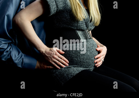 Eine Mutterschaft Bild von ein paar low-Key, schwarz im Hintergrund. Stockfoto