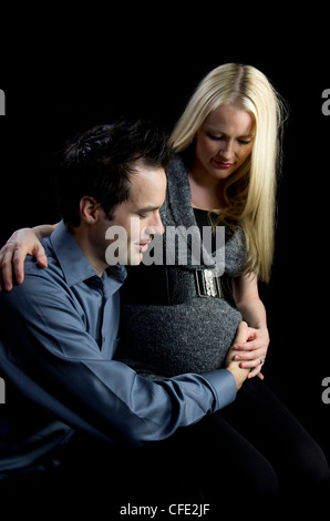 Eine Mutterschaft Bild von ein paar low-Key, schwarz im Hintergrund. Stockfoto