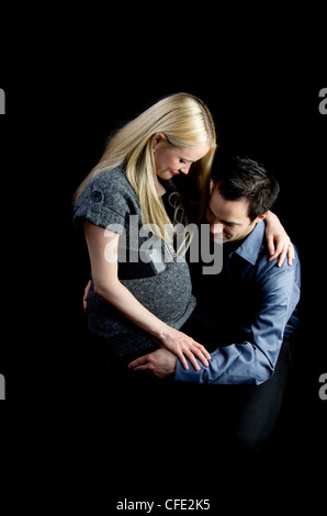 Eine Mutterschaft Bild von ein paar low-Key, schwarz im Hintergrund. Stockfoto