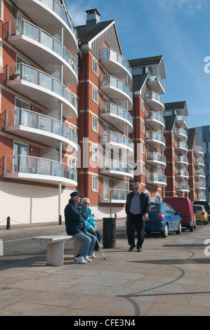 Mann und Frau sitzen auf Bank in Ipswich Docks. Ipswich, Suffolk, UK Stockfoto